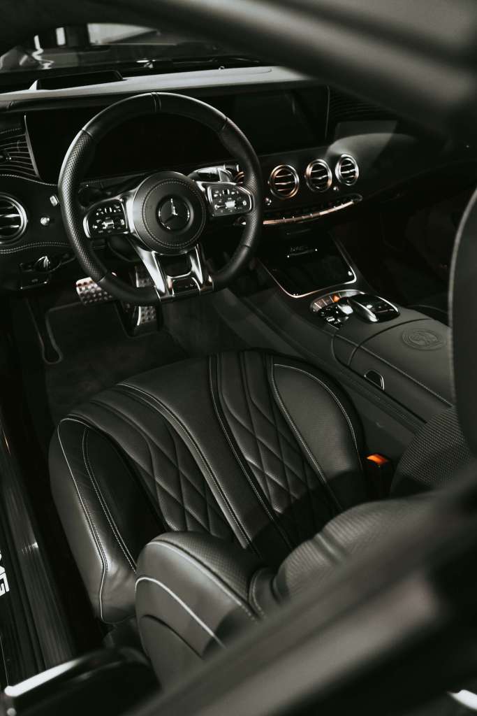 Luxurious black leather interior of a high-end car, showcasing professional detailing and upholstery cleaning services by Dennis Auto Details.
