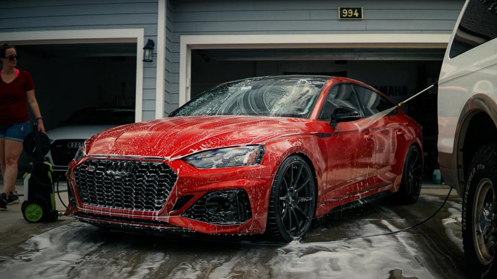 red car being washed by a garage