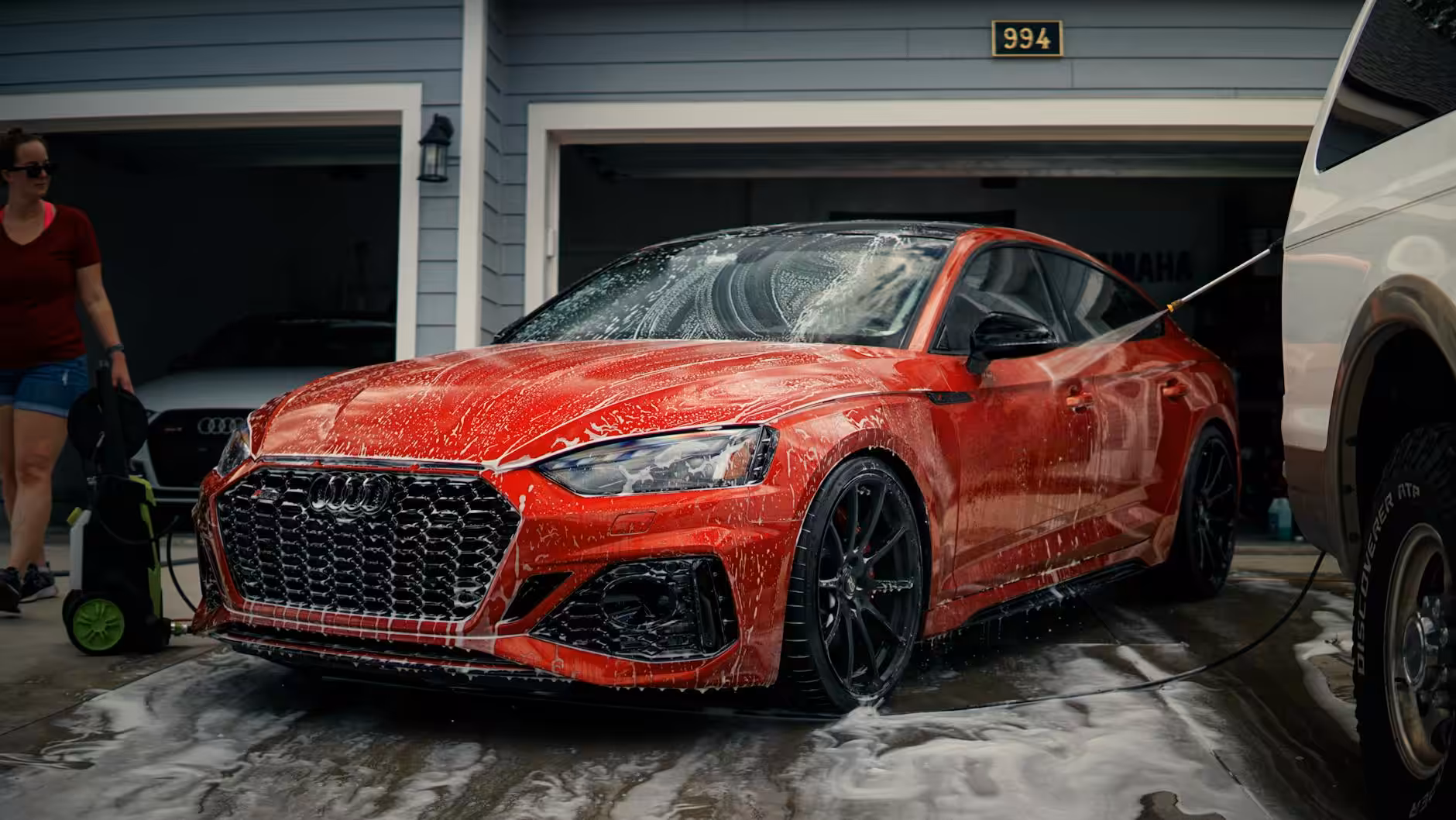 red car being washed by a garage - mobile car detailing san diego
