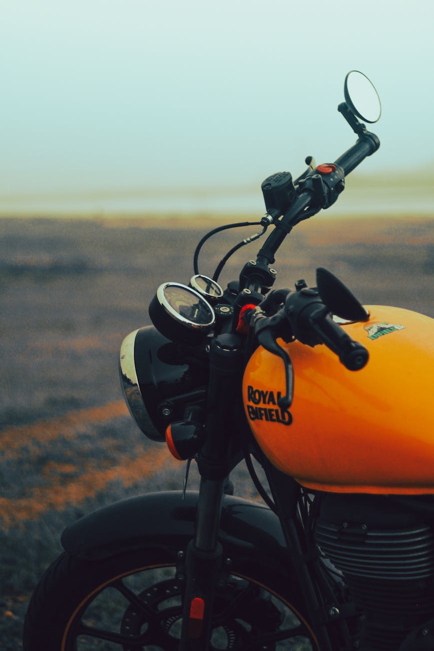 close up of a royal enfield motorcycle parked on a field
