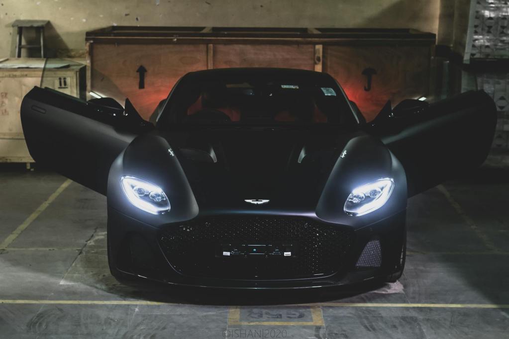 a black aston martin in a parking lot - aston martin car detailing by Dennis Auto Details